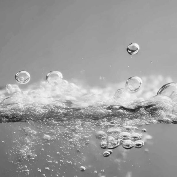 Cavitation bubbles in slow motion, black and white close-up of ultrasonic cleaning in action